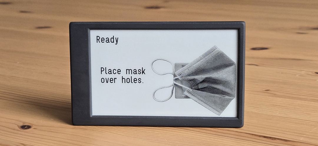 A Canary displaying the words Ready, Place mask over holes, with a line drawing of a respirator mask.